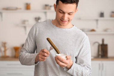 Mutfakta lezzetli sosis ve domates soslu genç adam.