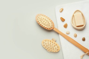 Gri arka planda farklı masaj fırçaları ve banyo malzemeleri.