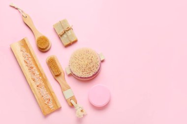 Renkli arkaplanda farklı masaj fırçaları ve banyo malzemeleri