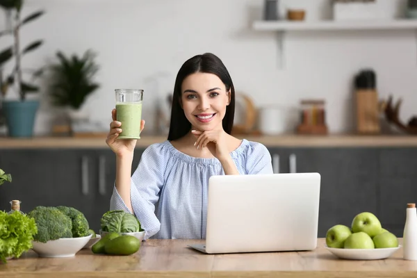 Young Woman Glass Smoothie Laptop Kitchen — Stockfoto