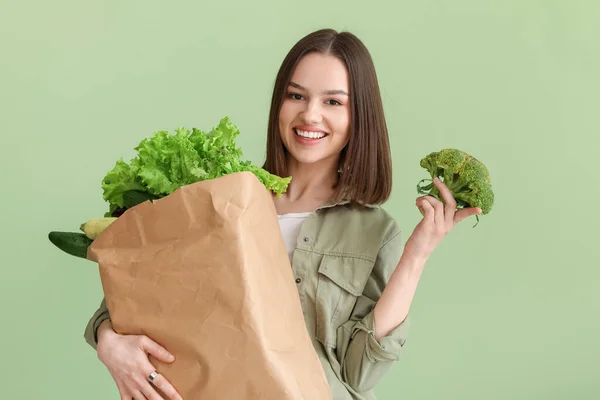 Ung Kvinna Och Papperspåse Med Färska Grönsaker Färg Bakgrund — Stockfoto