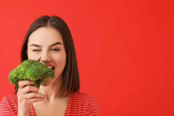 Young Woman Eating Fresh Broccoli Color Background — Stock Photo, Image