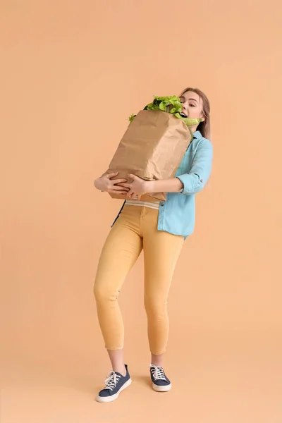 Junge Frau Und Papiertüte Mit Frischem Gemüse Auf Farbigem Hintergrund — Stockfoto