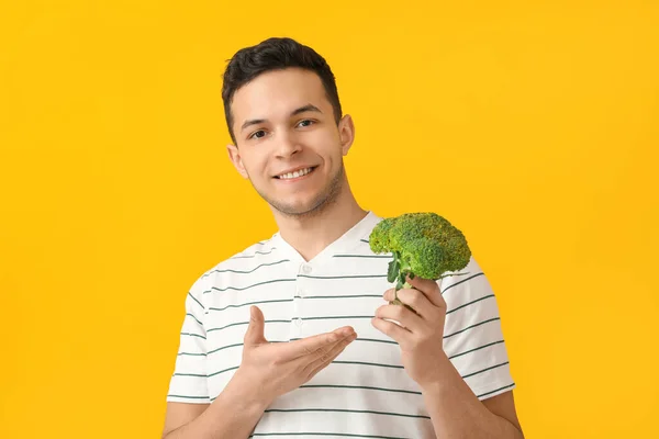 Hombre Joven Con Brócoli Fresco Sobre Fondo Color —  Fotos de Stock