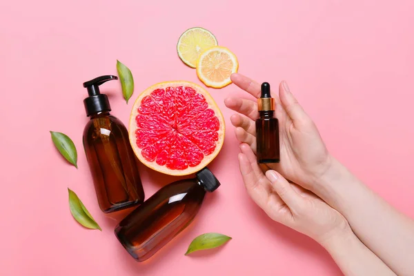 Female Hands Bottles Essential Oil Citrus Fruits Color Background — Stock Photo, Image