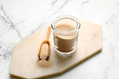 Kavanoz ve kepçe açık arkaplanda etkin kuru maya