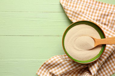 Renkli ahşap arka planda etkin kuru maya ile kase