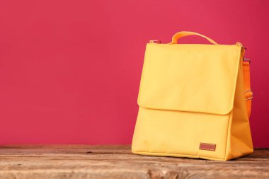 Beslenme çantası ahşap masada renk arkaplanına karşı