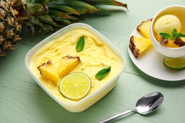 Renkli ahşap arka planda lezzetli ananaslı dondurma kabı