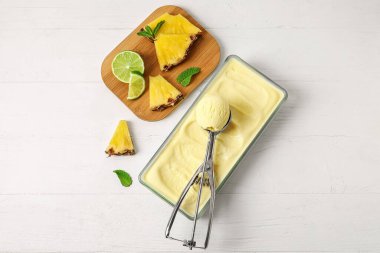 Hafif ahşap arka planda bir kepçe lezzetli ananaslı dondurma.