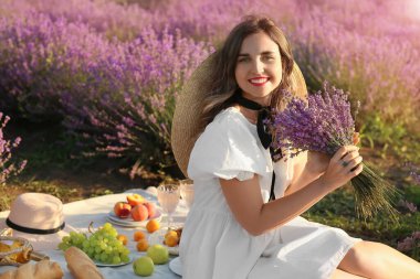 Güzel genç bayan lavanta tarlasında piknik yapıyor.