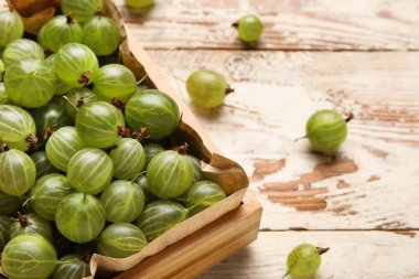 Tahta arka planda taze bektaşi üzümü dolu bir kutu.