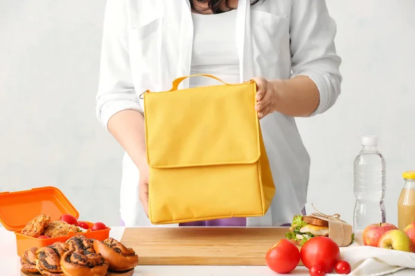 台所で弁当箱の袋を持つ女性 — ストック写真