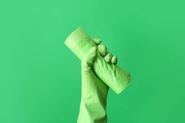 Arka planda çöp torbası rulosu olan kauçuk eldiven verin.