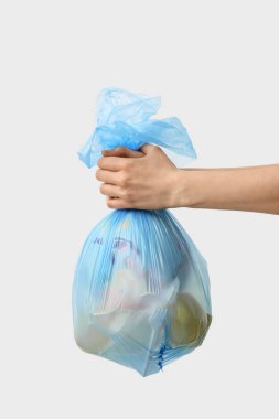 Beyaz arka planda çöp torbası olan bir kadın.