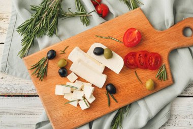 Beyaz ahşap arka planda lezzetli peynir parçaları olan tahta.