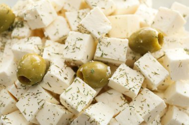 Arka planda zeytin aromalı lezzetli peynir parçaları.