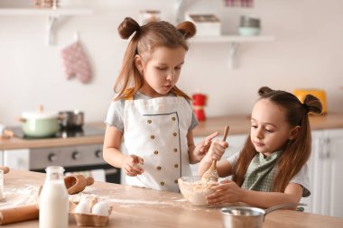 Sevimli küçük kız kardeşler mutfakta para kazanıyor.