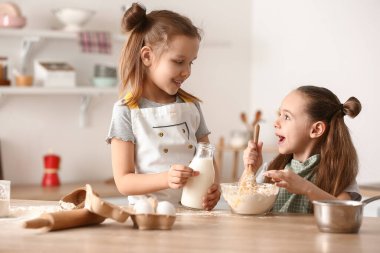 Sevimli küçük kız kardeşler mutfakta para kazanıyor.