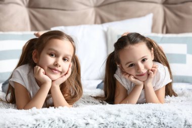 Evdeki yatakta tatlı küçük kız kardeşler.