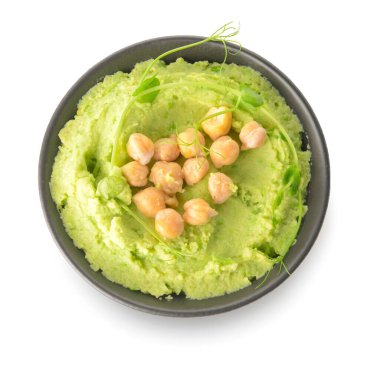 Bowl with tasty green pea hummus on white background clipart