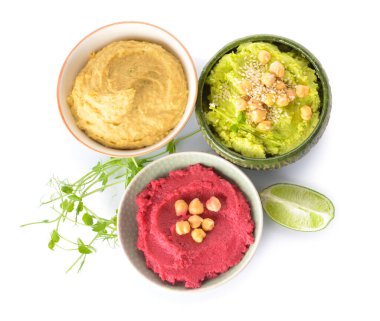 Bowls with tasty hummus and lime on white background