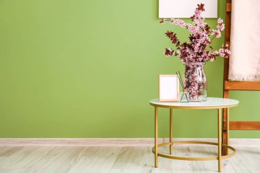 Odada çiçek açan dalları olan bir vazo.