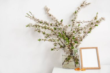 Odada çiçek açan güzel dalları olan bir vazo.