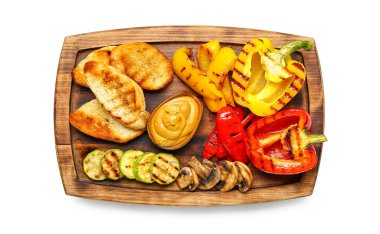 Lezzetli ızgara sebzeli pano ve beyaz arka planda ekmek