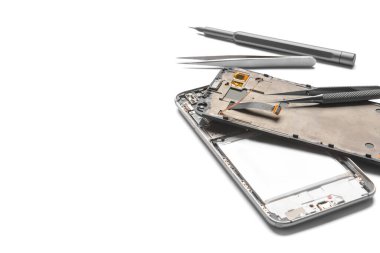 Disassembled mobile phone with technician tools on white background