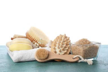 Beyaz arka planda farklı masaj fırçaları ve banyo malzemeleri.