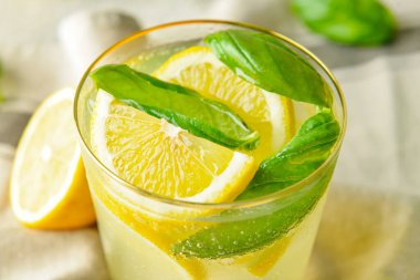 Gri arka planda fesleğenli lezzetli bir limonata.