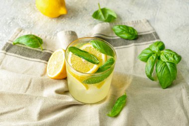 Gri arka planda fesleğenli lezzetli bir limonata.
