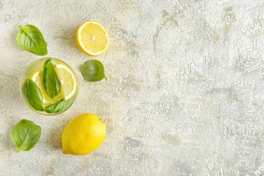 Gri arka planda fesleğenli lezzetli bir limonata.