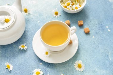 Lezzetli bir çiçek çayı ve renkli bir çaydanlık.