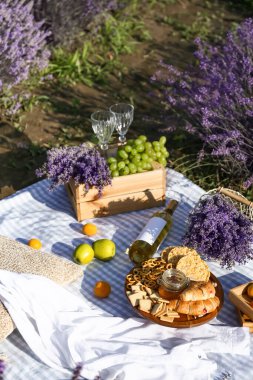 Lavanta tarlasında romantik piknik için lezzetli yemekler ve içecekler.