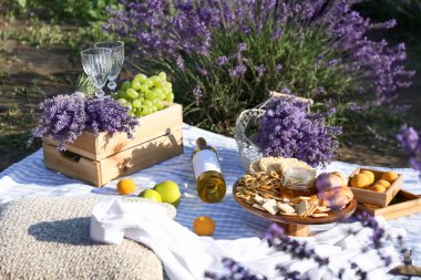 Lavanta tarlasında romantik piknik için lezzetli yemekler ve içecekler.