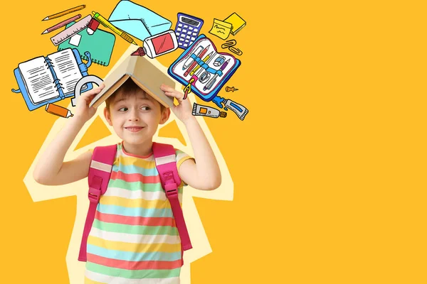 Cute little schoolboy with book on color background