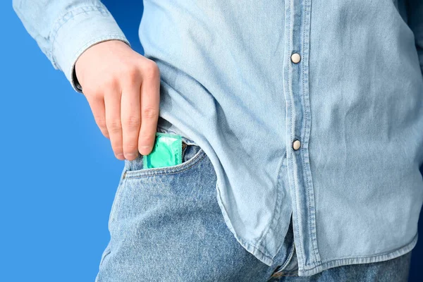 Man Putting Condom Pocket Jeans Color Background Closeup — Stock Photo, Image