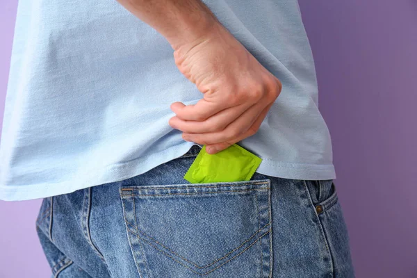 Man Putting Condom Pocket Jeans Color Background Closeup — Stock Photo, Image