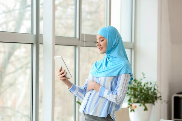 妊娠中のイスラム教徒の女性はオフィスでタブレットコンピュータを使用して — ストック写真