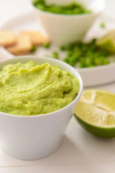 Bowl Ízletes Zöld Borsó Hummus Mész Világos Háttér Közelkép — Stock Fotó