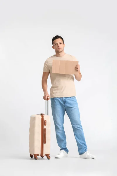 Junger Mann Mit Pappe Und Koffer Auf Hellem Hintergrund — Stockfoto