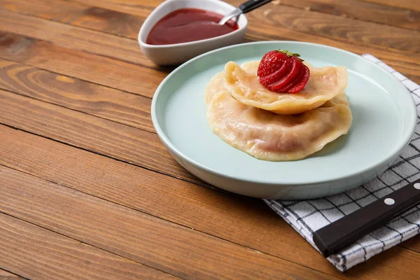 Plate Tasty Strawberry Dumplings Sauce Wooden Background — Φωτογραφία Αρχείου