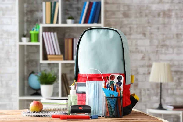 Schulrucksack Mit Schreibwaren Und Medizinischer Maske Auf Tisch Klassenzimmer — Stockfoto