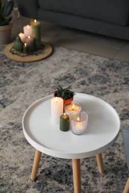 Oturma odasındaki masada mum yakmak.