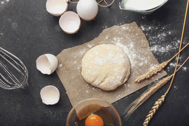 Koyu arkaplanda fırın ve kap kacak hazırlamak için malzemeli taze hamur.