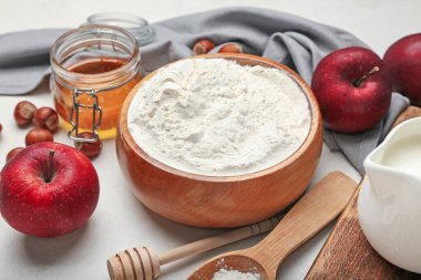 Hafif arka planda fırın, elma ve fındık hazırlamak için gerekli malzemeler