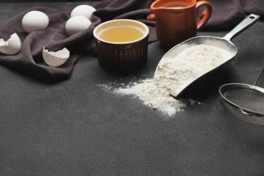 Koyu arkaplanda fırın ve çatal bıçak hazırlamak için gerekli malzemeler