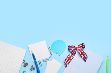 Stationery and ribbon in colors of UK flag on blue background. Concept of learning English clipart